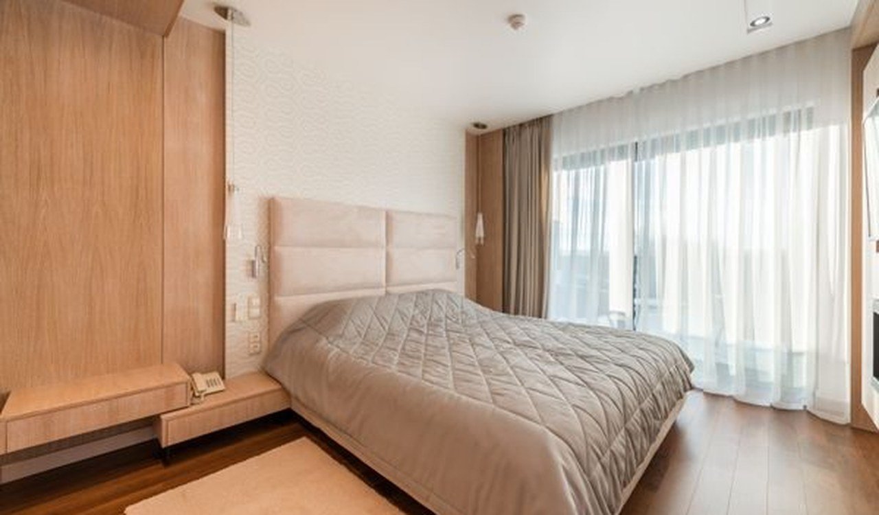 Furnished bedroom with a bed and curtains